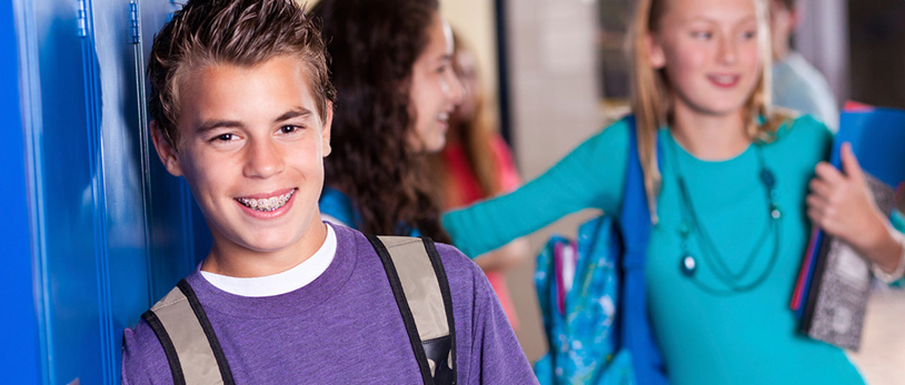 Kids smiling in a school hallway - Boy smiling in the foreground